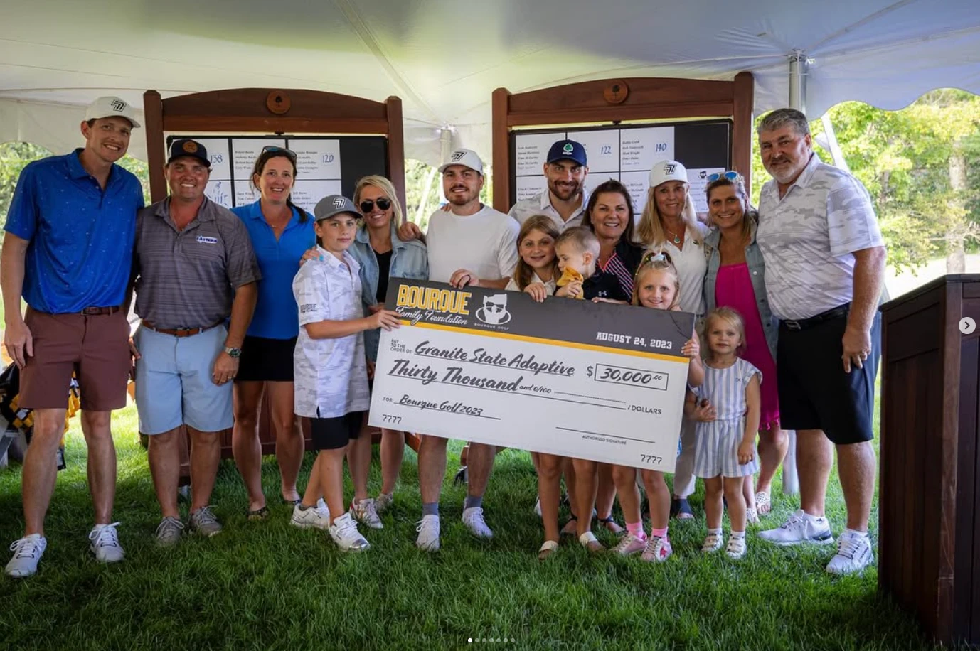 A group at the Bourque Golf tournament holding an oversized Bourque Family Foundation check, posted on Instagram